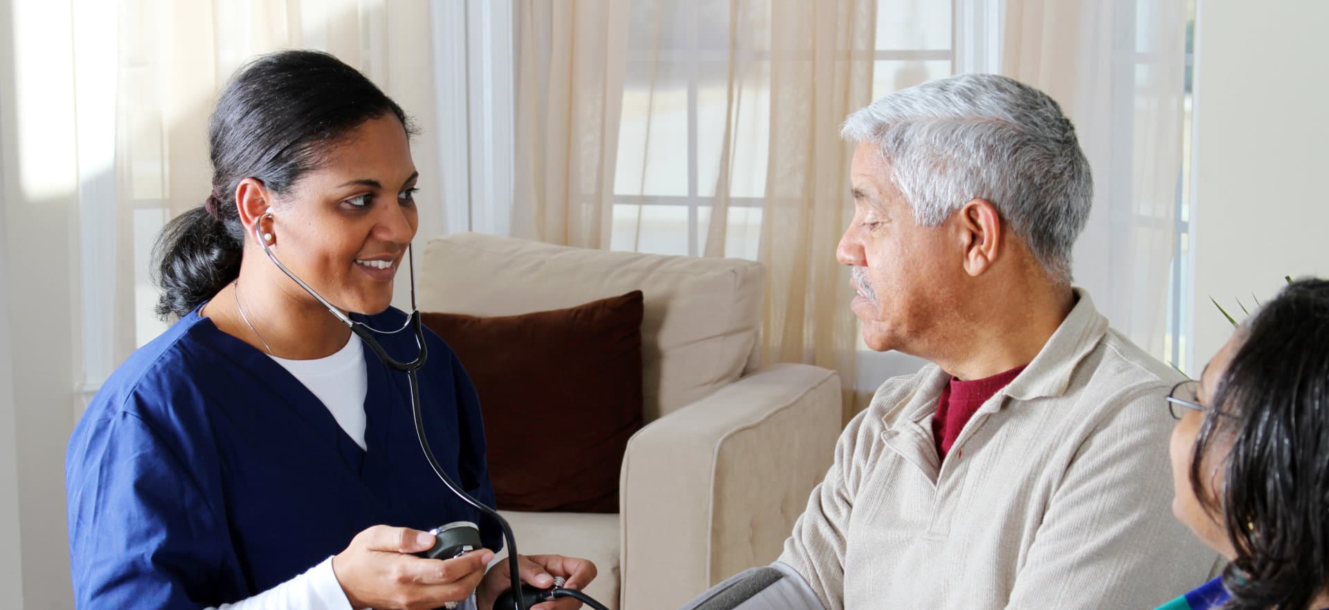 caregiver checking up an elderly couple