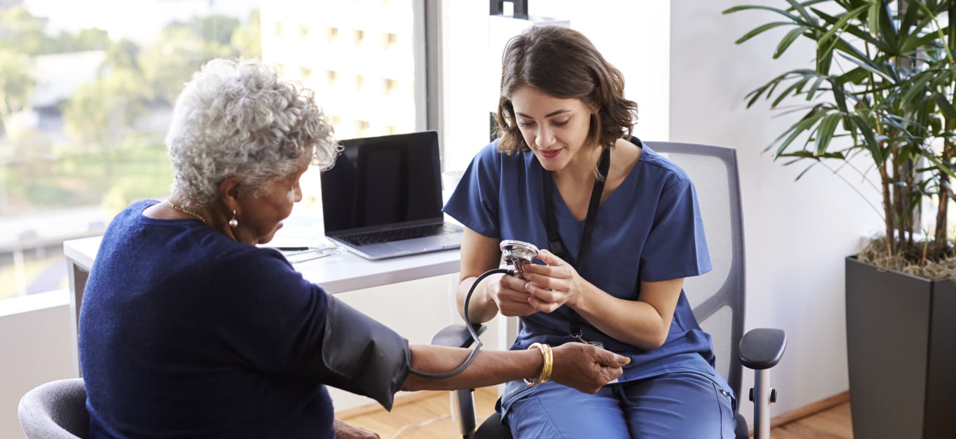 caregiver checking up an elderly woman