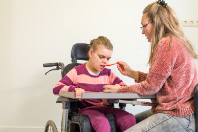 nurse helping her disable patient to eat