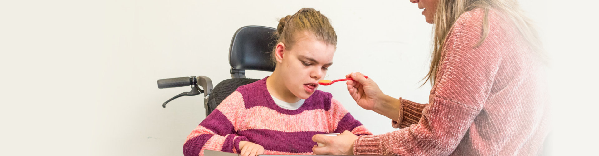 nurse helping her disable patient to eat