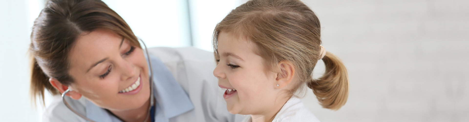 Doctor examining little girl with stethoscope